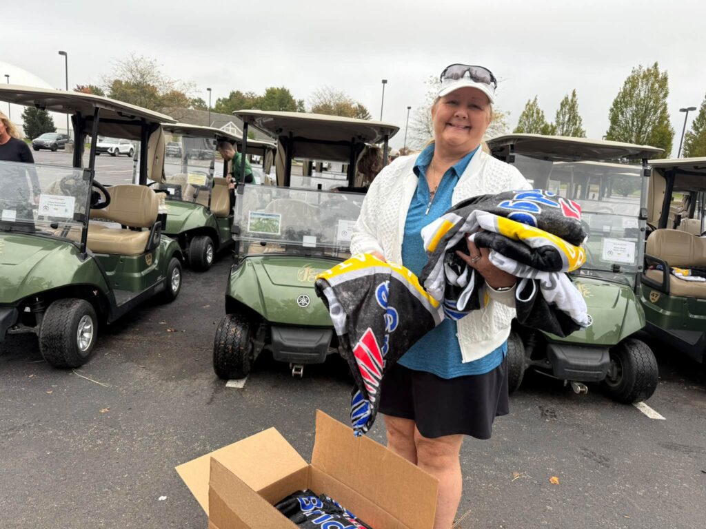 A volunteer handing out First Responders’ Bridge player gifts in the cart lot